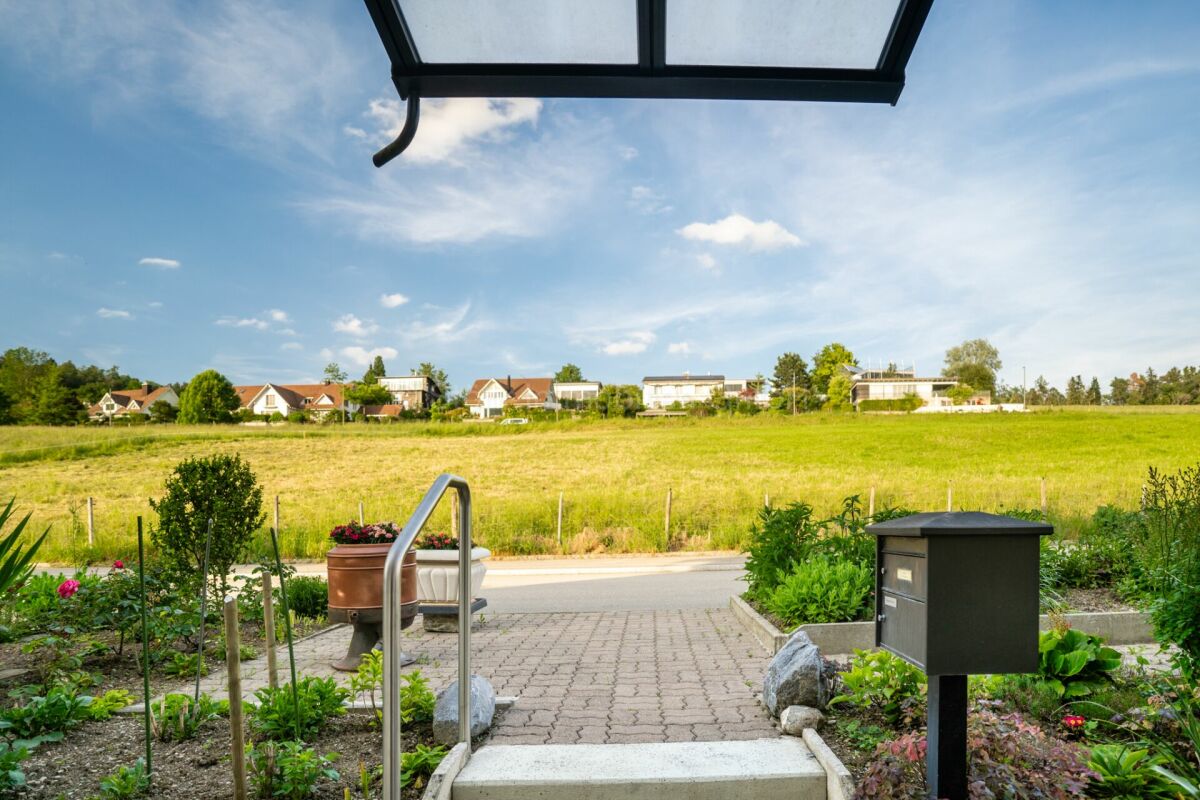 Blick von einer Terrasse auf Wiese und Häuser