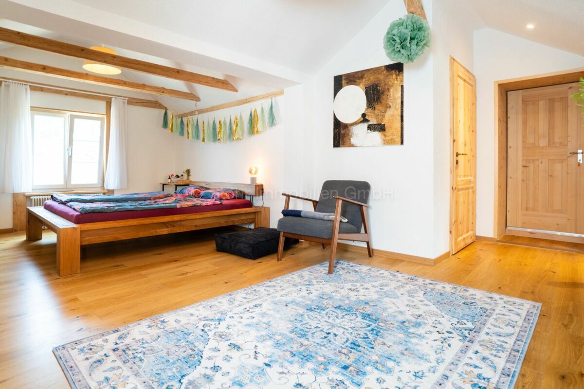 Helles Schlafzimmer mit Holzbalken und Naturholz