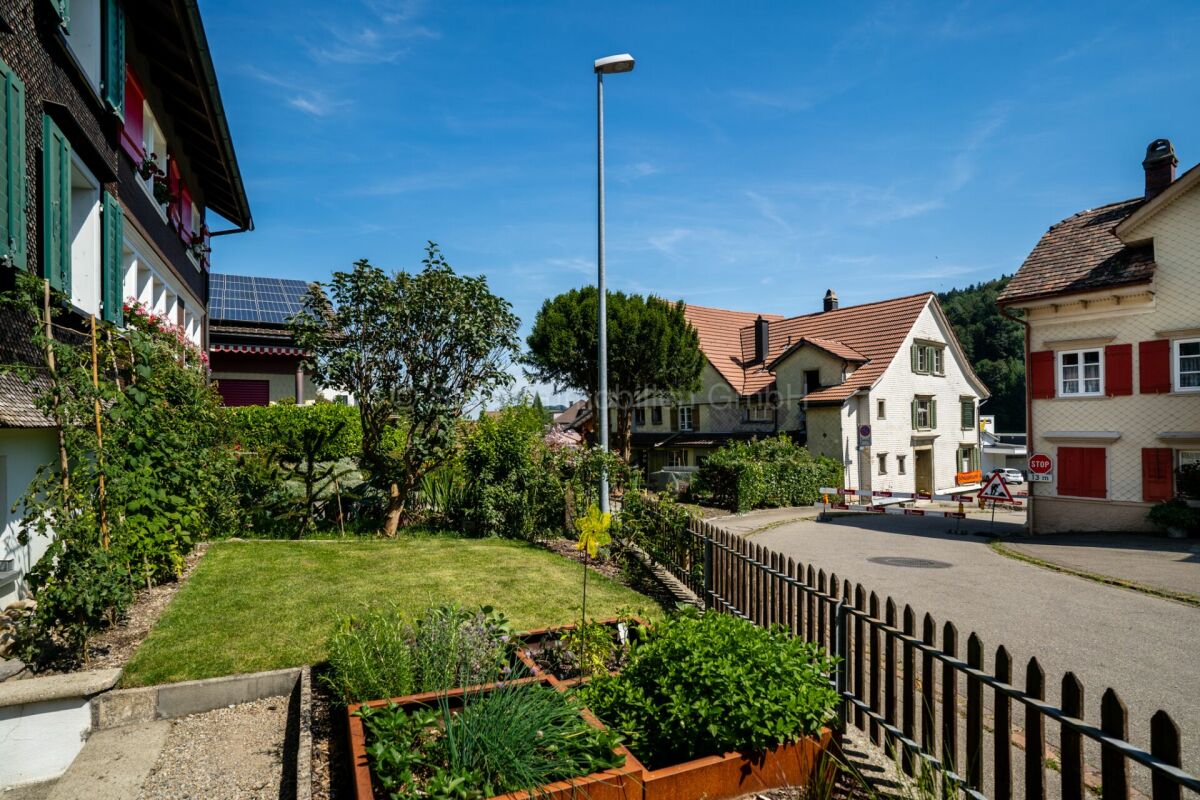 Wohnhaus mit Garten und Straßenansicht
