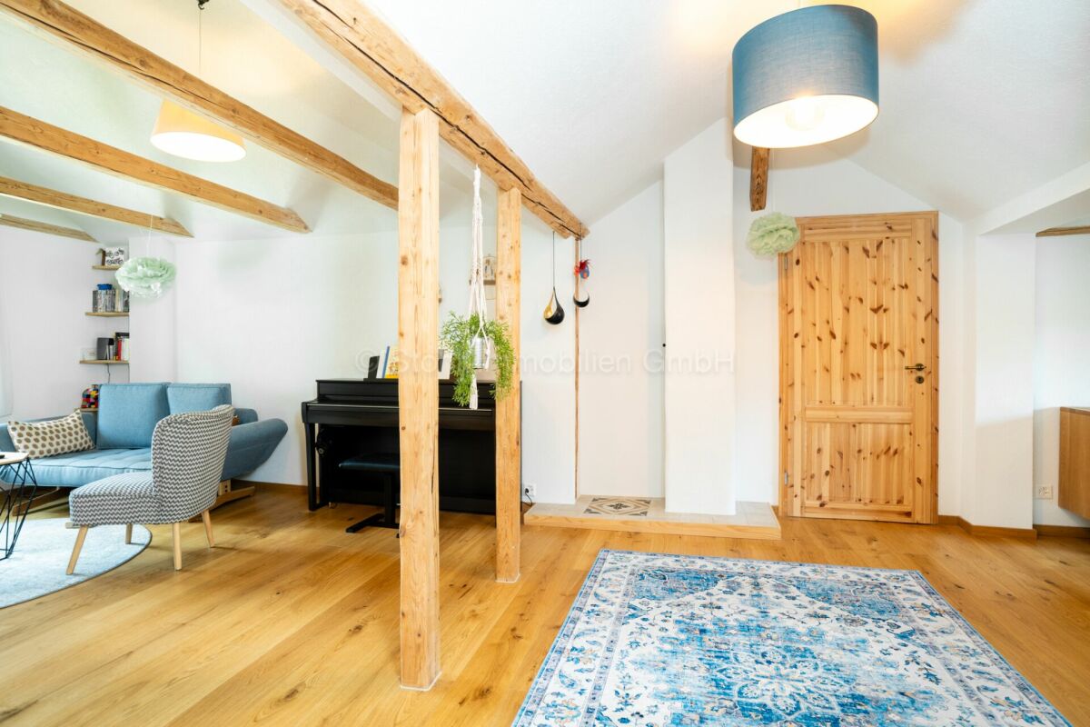 Gemütlicher Wohnraum mit Holzbalken und Klavier