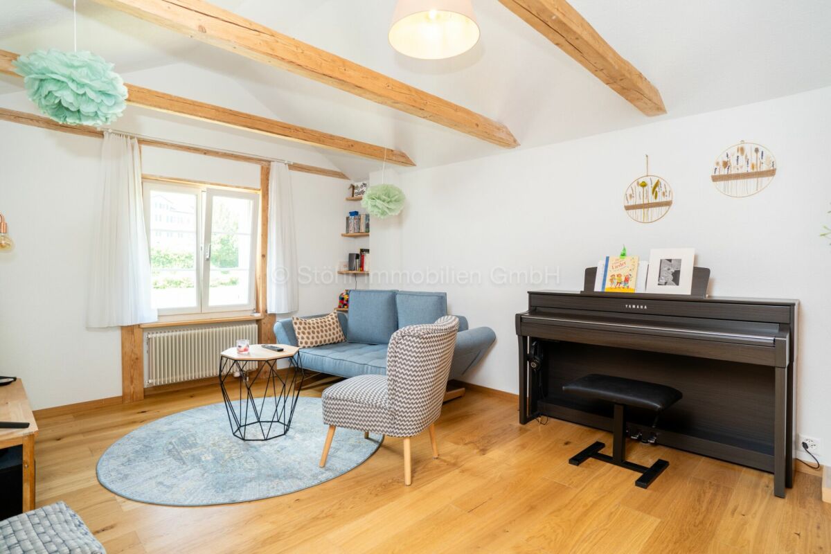 Helles Wohnzimmer mit Klavier und Holzbalken