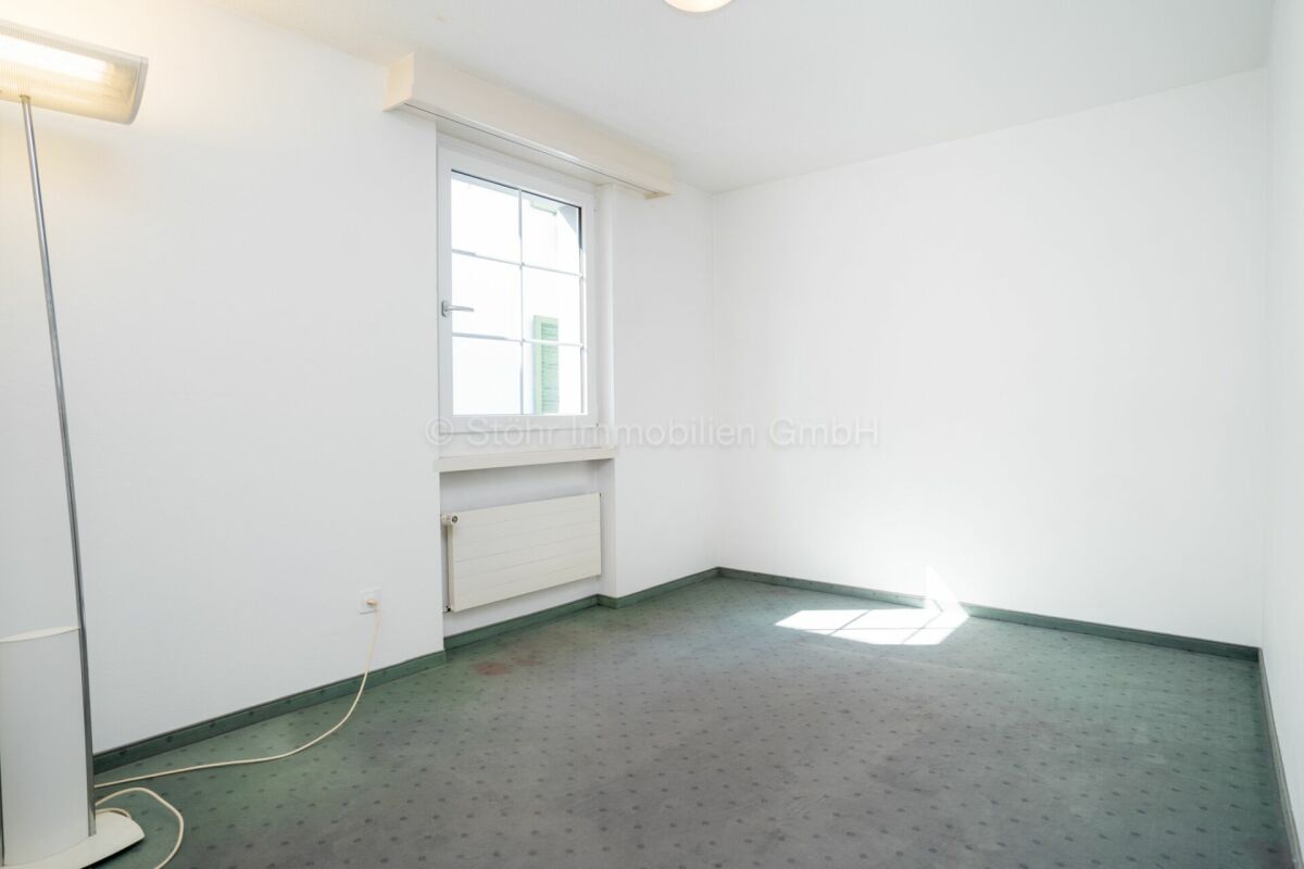 Leeres, helles Zimmer mit Fenster und Heizkörper