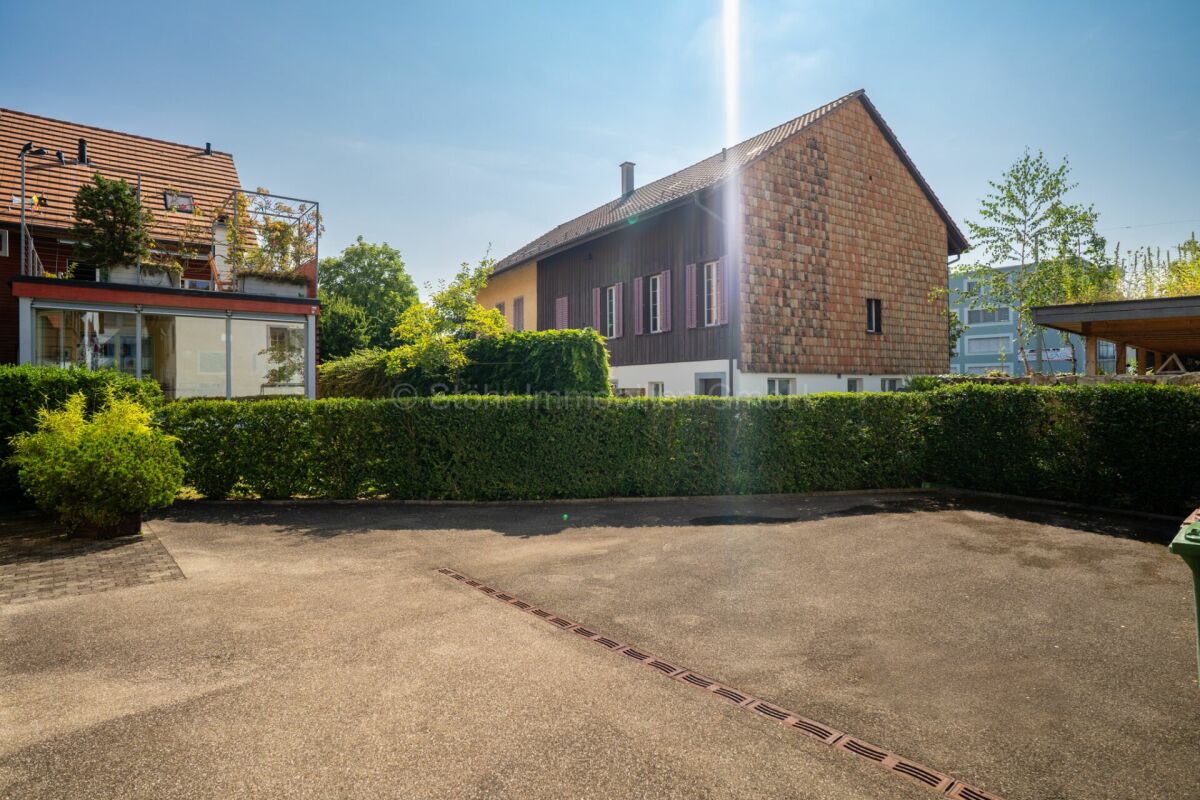 Außenansicht eines Wohnhauses mit Hof und Hecken