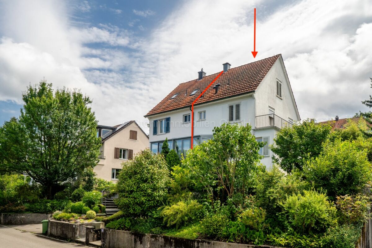 Wohnhaus mit rotem Satteldach und grünem Garten