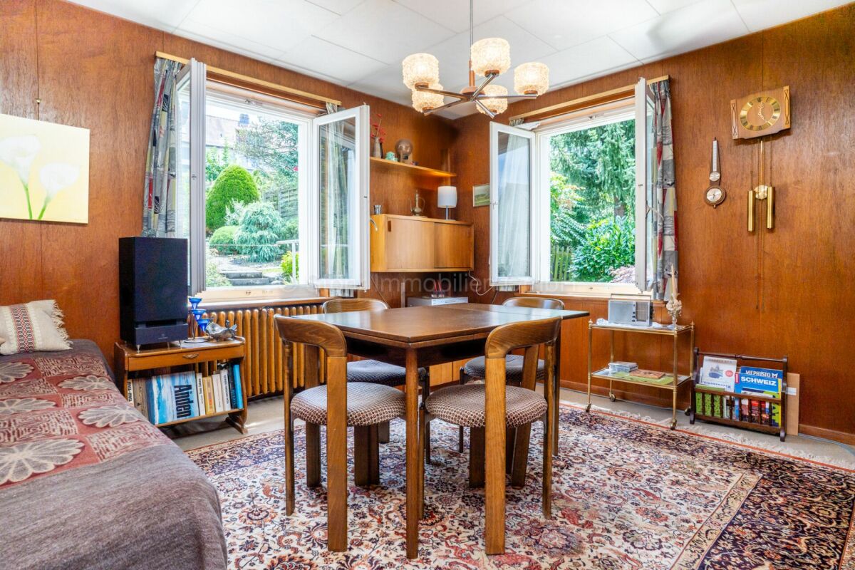 Wohnzimmer mit Essbereich und Holzvertäfelung