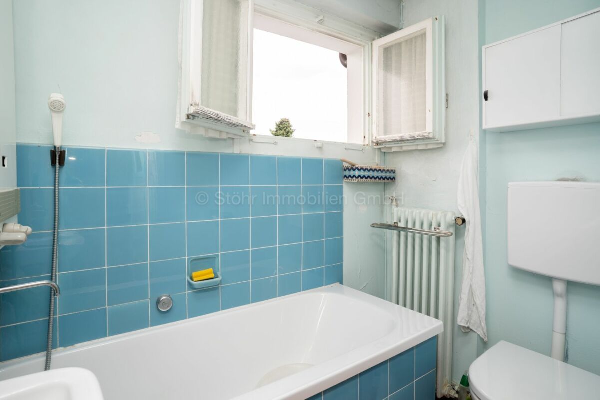 Kleines helles Badezimmer mit Badewanne und Fenster