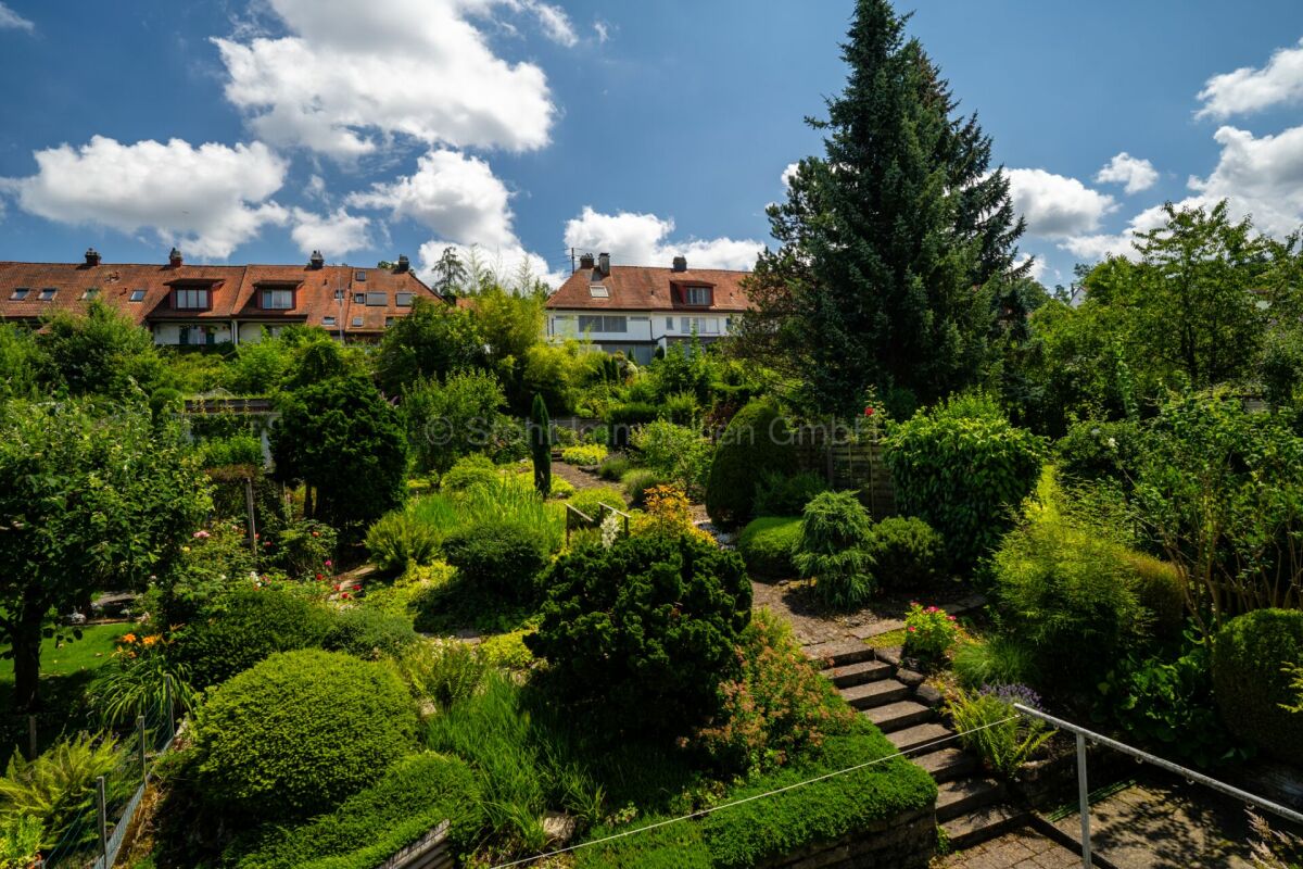 Großer Garten mit Wohnhäusern im Hintergrund
