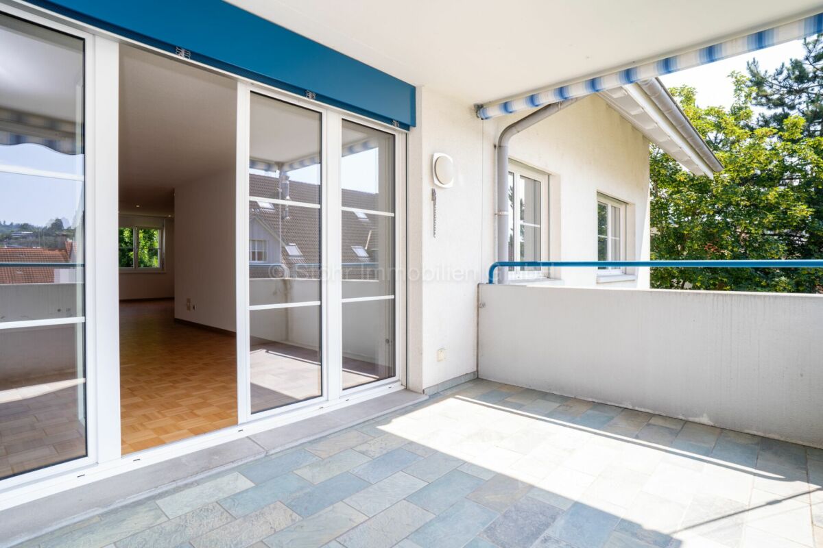 Balkon mit Schiebetür und Blick ins Grüne