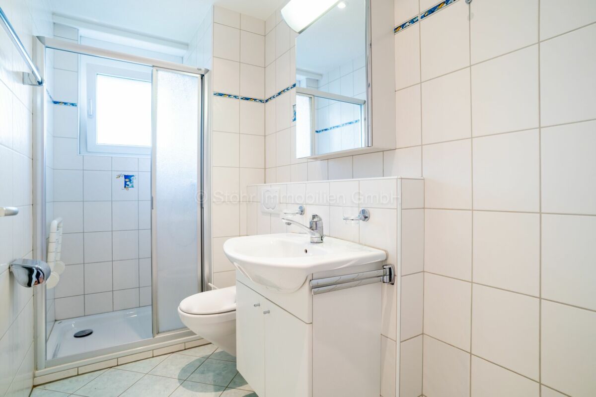 Kleines Badezimmer mit Dusche und Waschtisch
