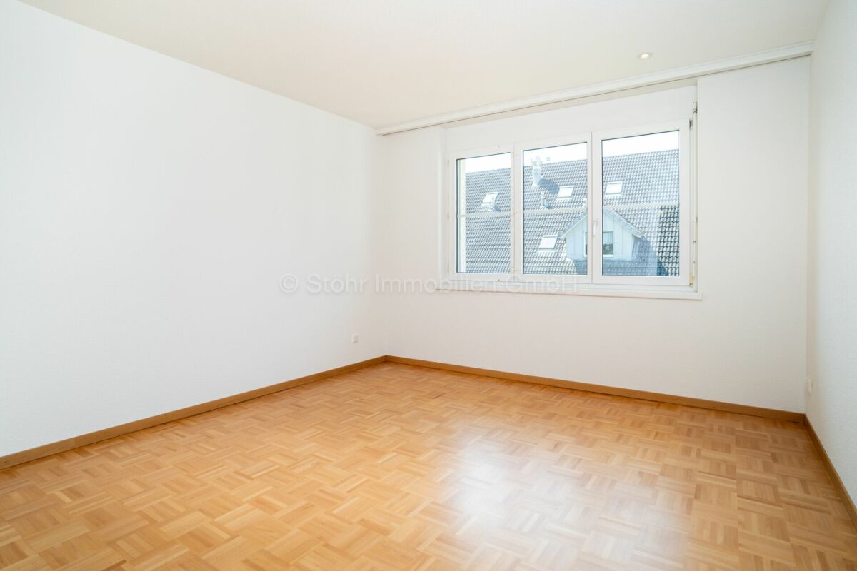 Heller leerer Raum mit Parkettboden und Fenster