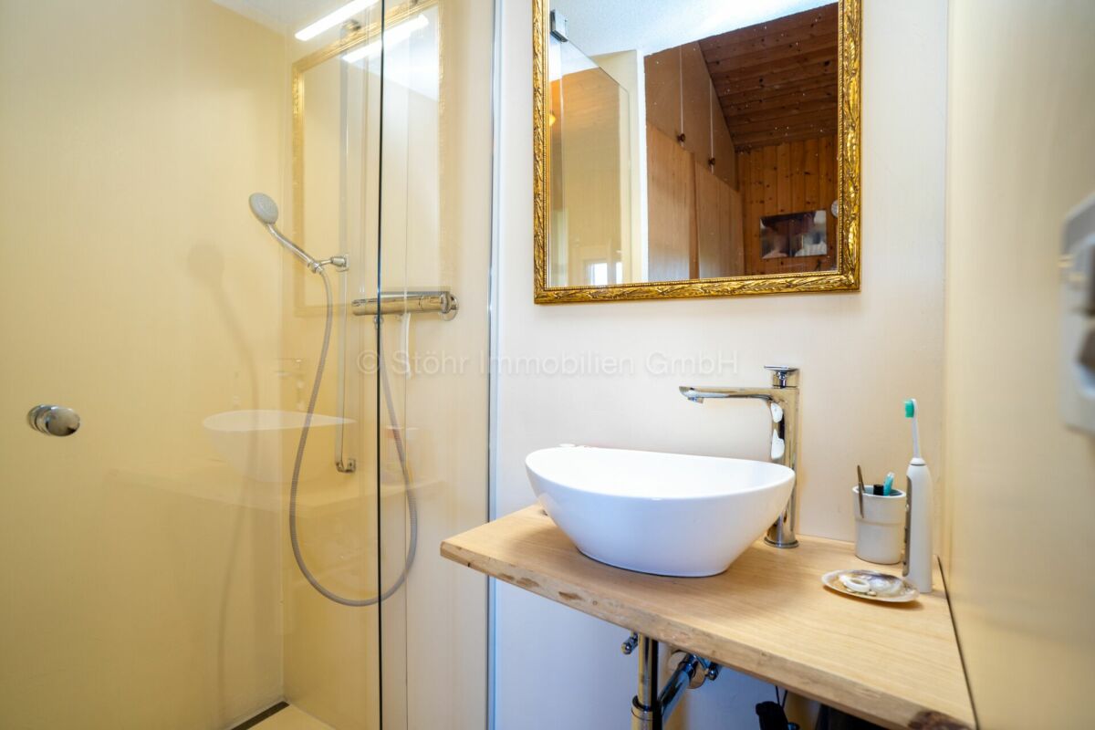 Kleines Badezimmer mit Dusche und Waschtisch