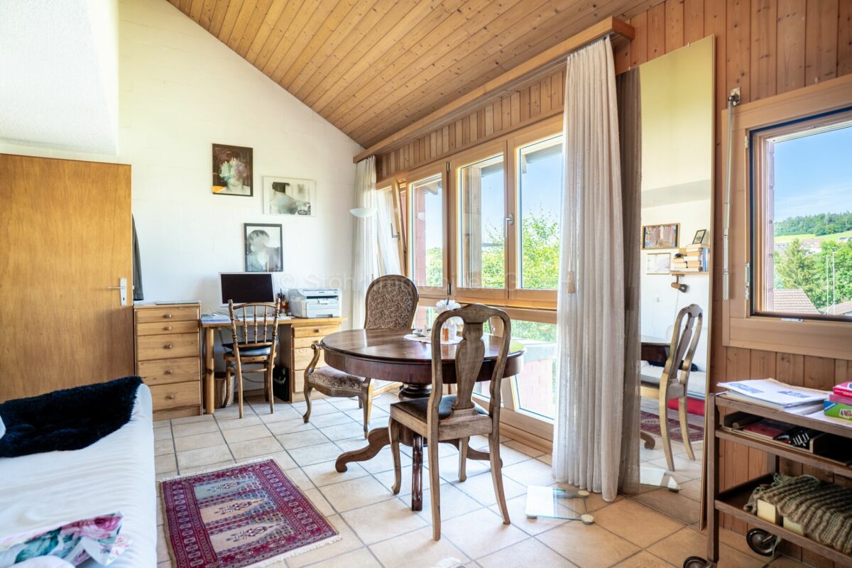 Heller Wohnraum mit Holzdecke und großen Fenstern