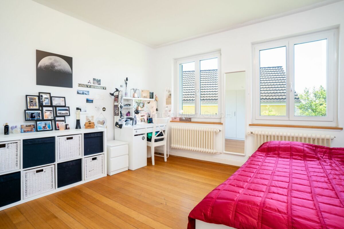 Helles Schlafzimmer mit zwei Fenstern und Stauraum