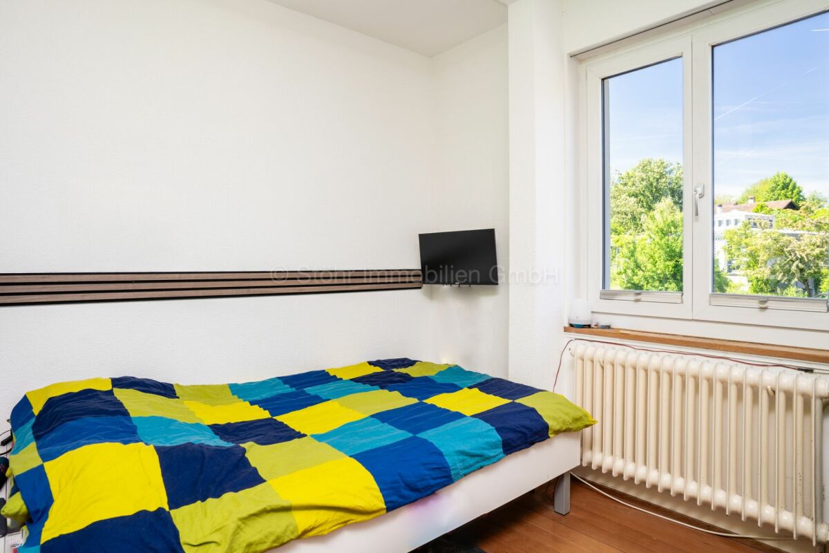 Helles Schlafzimmer mit Fenster und Bett