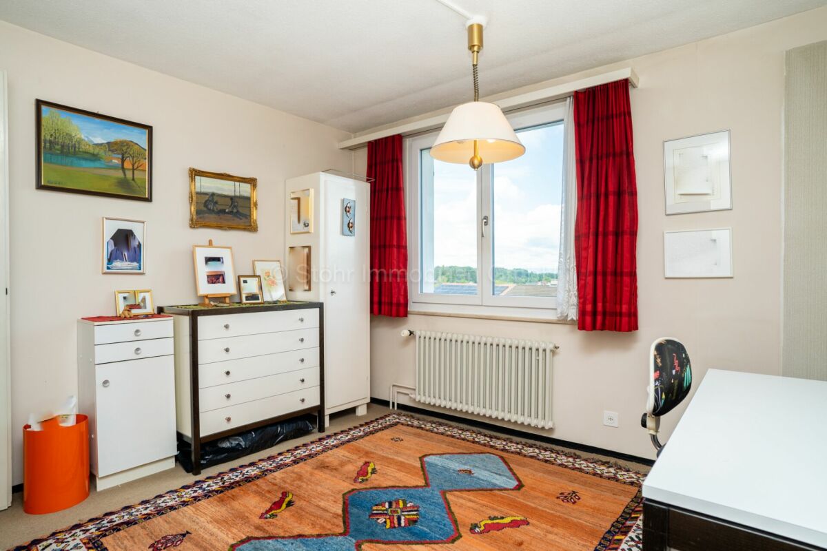Helles Arbeits- bzw. Kinderzimmer mit Fenster, Teppich und Möbeln