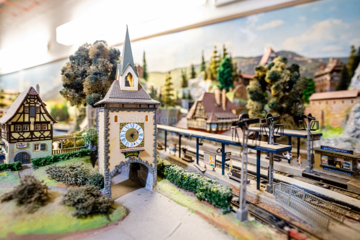 Modelllandschaft mit Miniaturbahnhof und Kirchturm