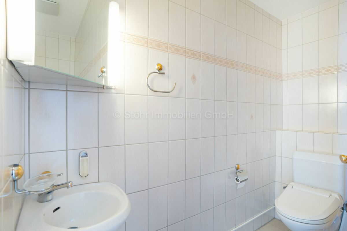 Gäste-WC mit weißer Fliesenverkleidung