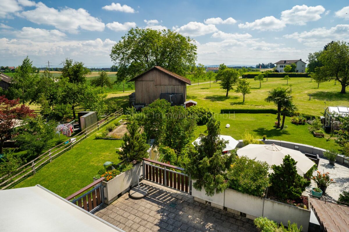 Ländlicher Garten mit Terrasse und Nebengebäude