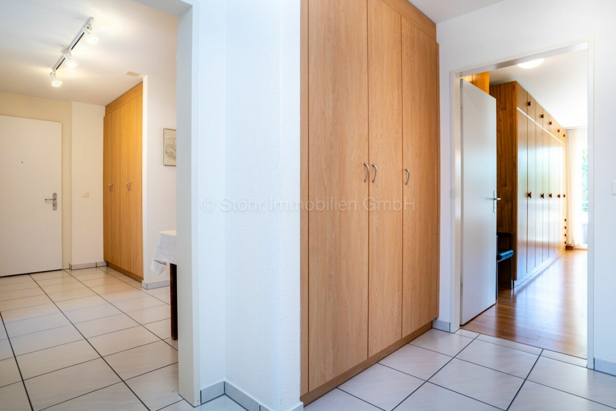 Heller Eingangsbereich mit Fliesenboden und Holz-Einbauschränken