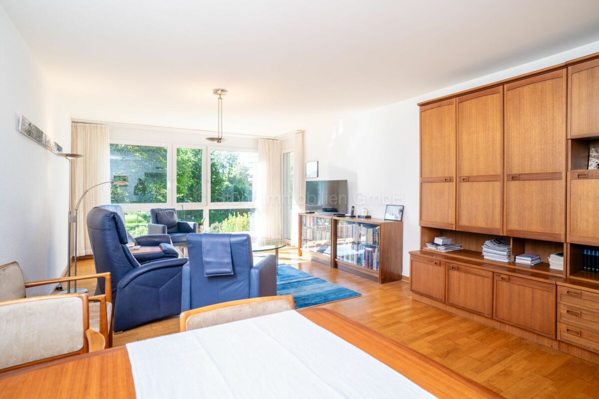 Wohnzimmer mit großer Fensterfront und Holzschrankwand