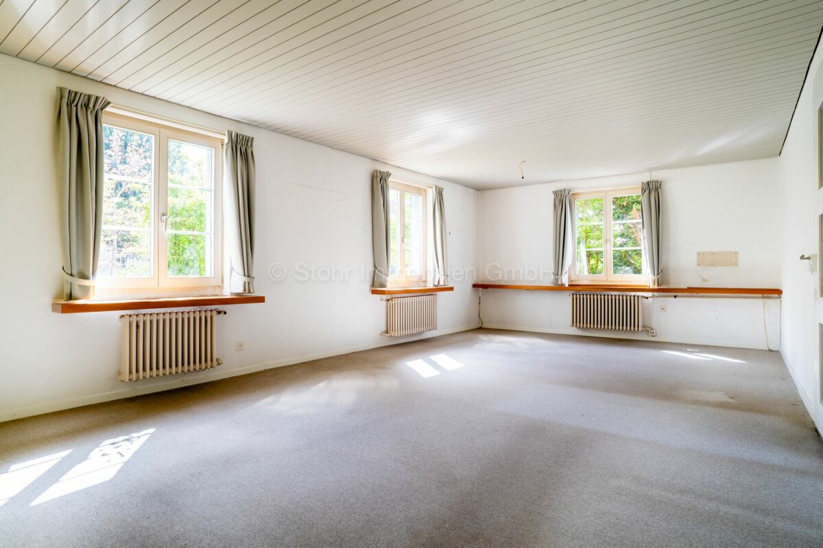 Heller leerer Wohnraum mit mehreren Fenstern