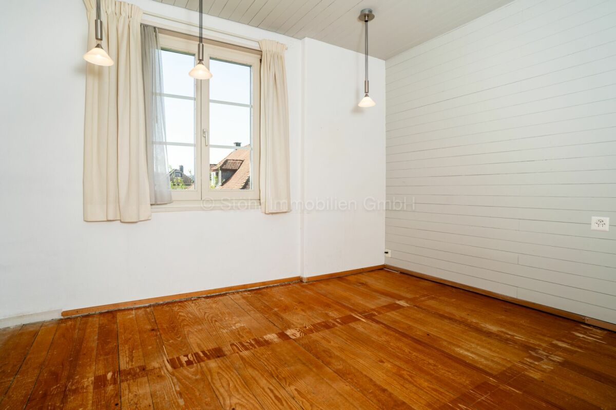 Heller leerer Raum mit Holzboden und Fenster