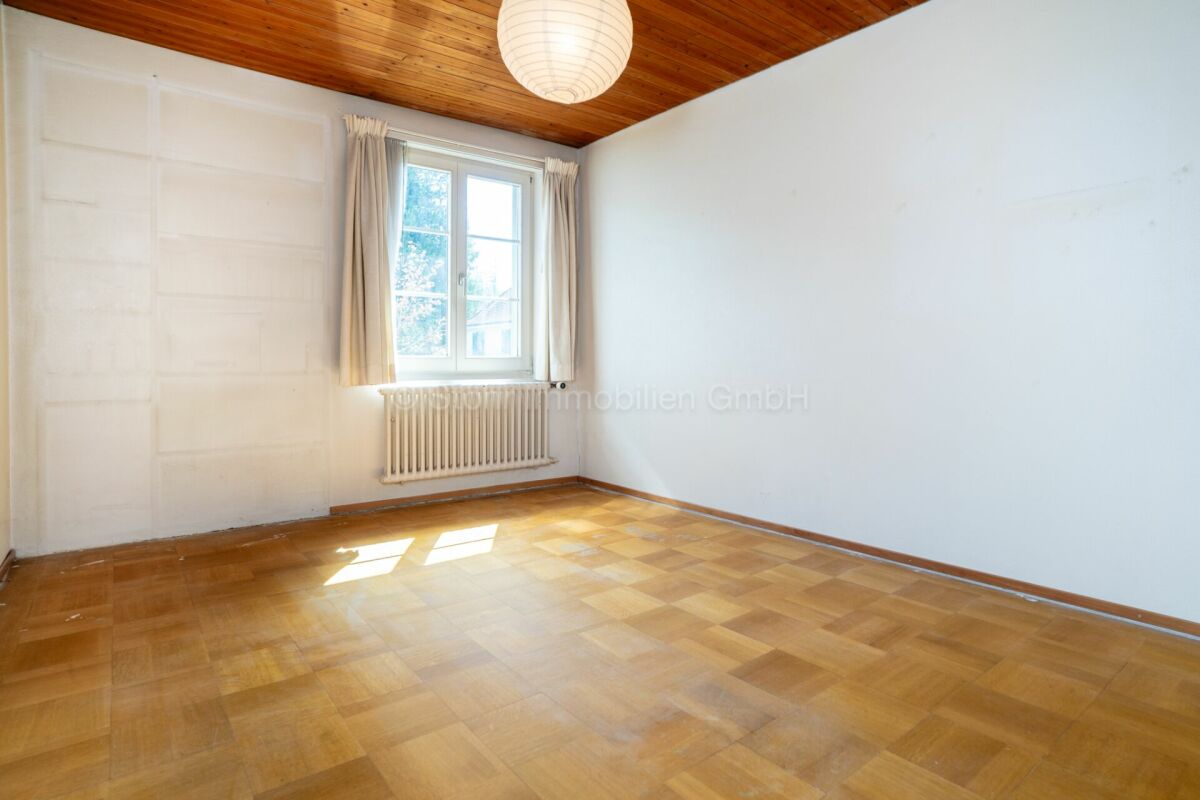 Leerer Raum mit Holzdecke und Parkett