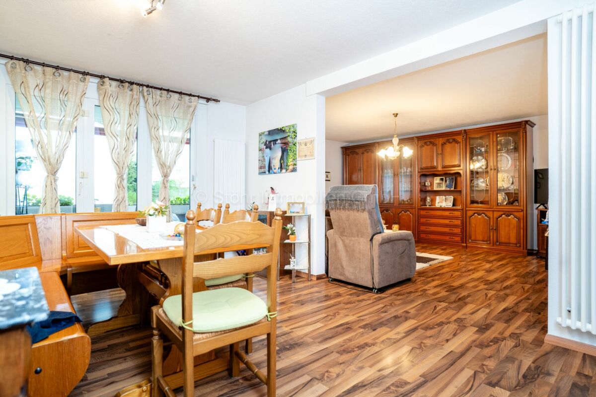 Wohn- und Essbereich mit Holzoptik und Vitrine
