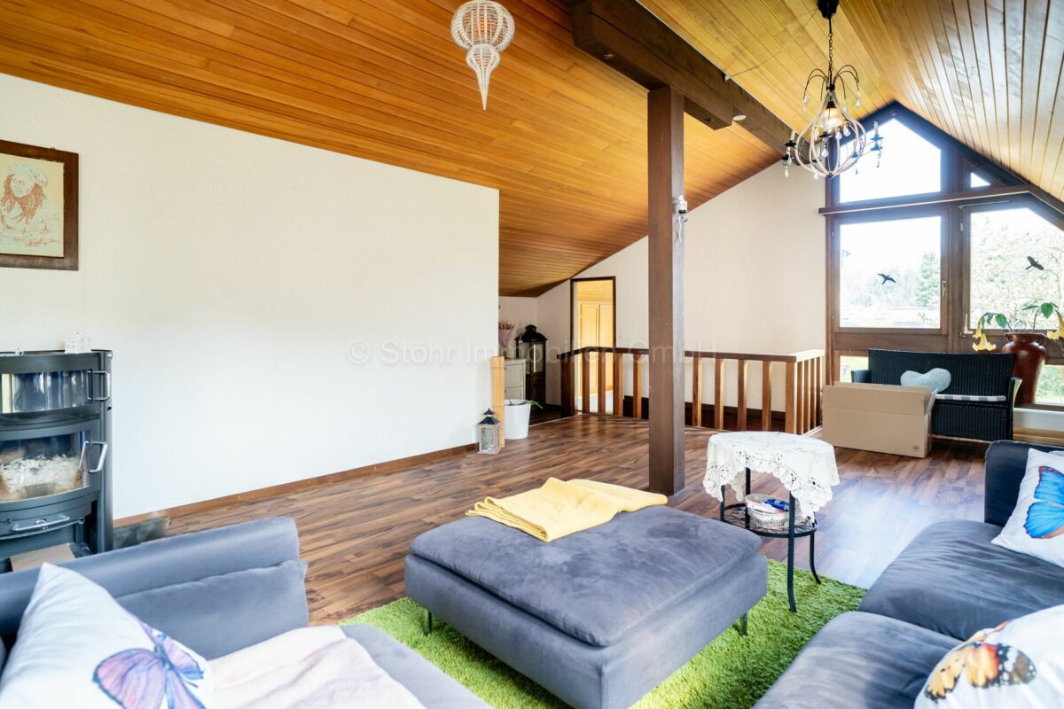 Heller Dachgeschoss-Wohnraum mit Holzdecke und großen Fenstern