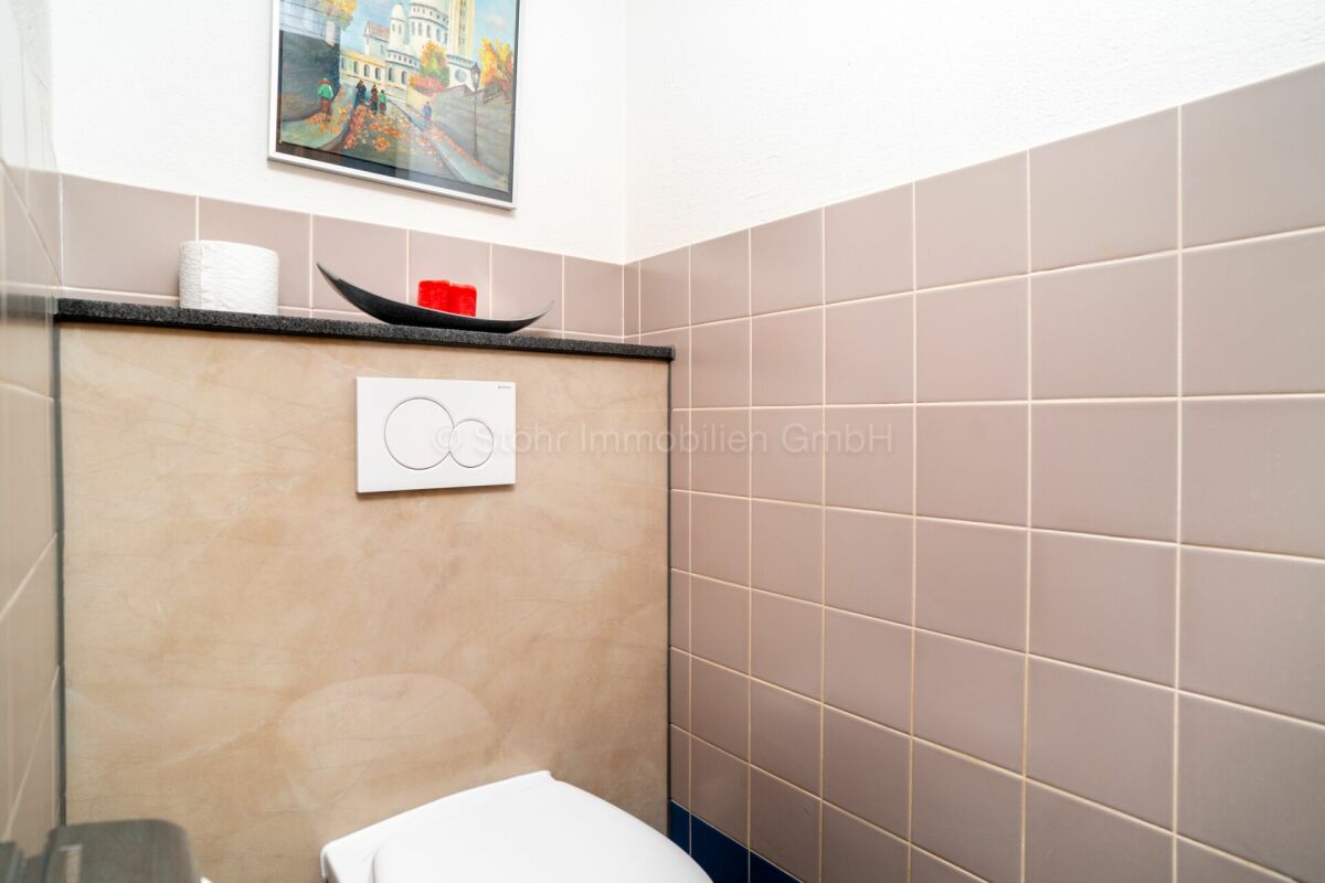 Gäste-WC mit Spülkasten und Wandfliesen