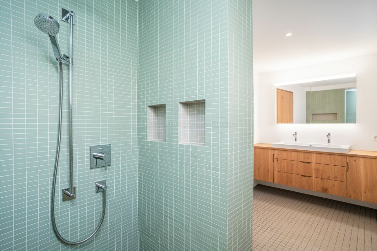 Modernes Badezimmer mit mintgrüner Duschzone und Holzwaschtisch