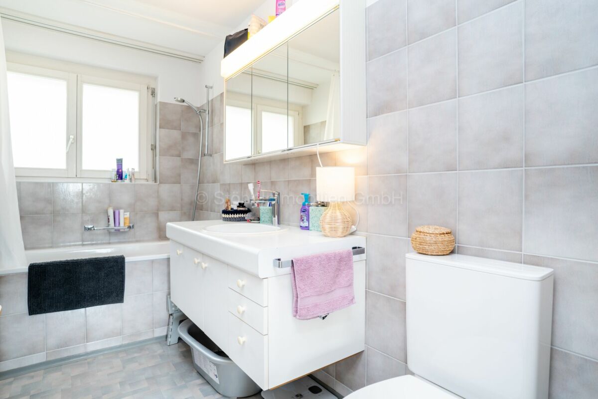 Helles Badezimmer mit Wanne, Waschtisch und Spiegelschrank