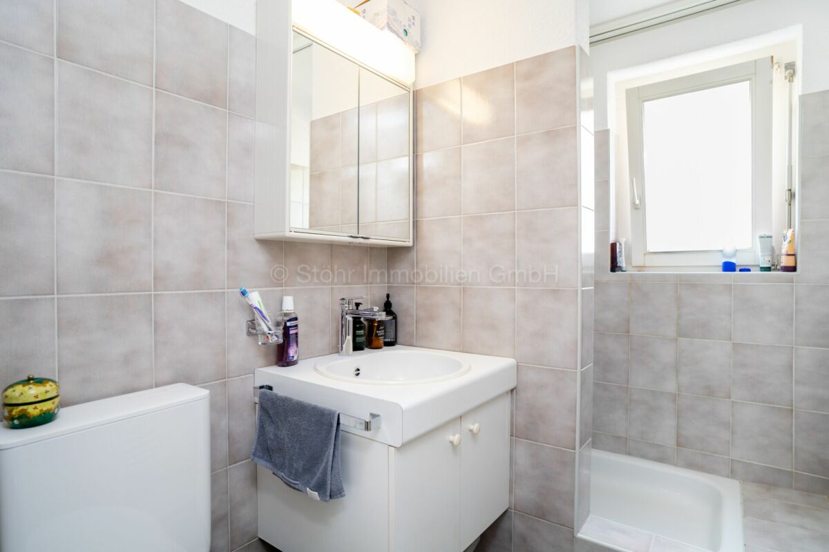 Kleines helles Badezimmer mit Waschbecken und Wanne