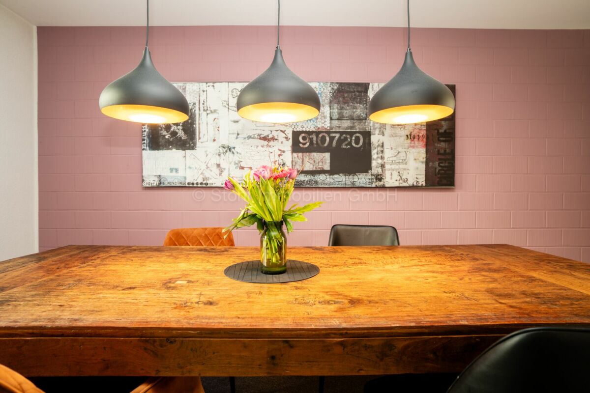 Esszimmer mit großem Holztisch und Pendelleuchten