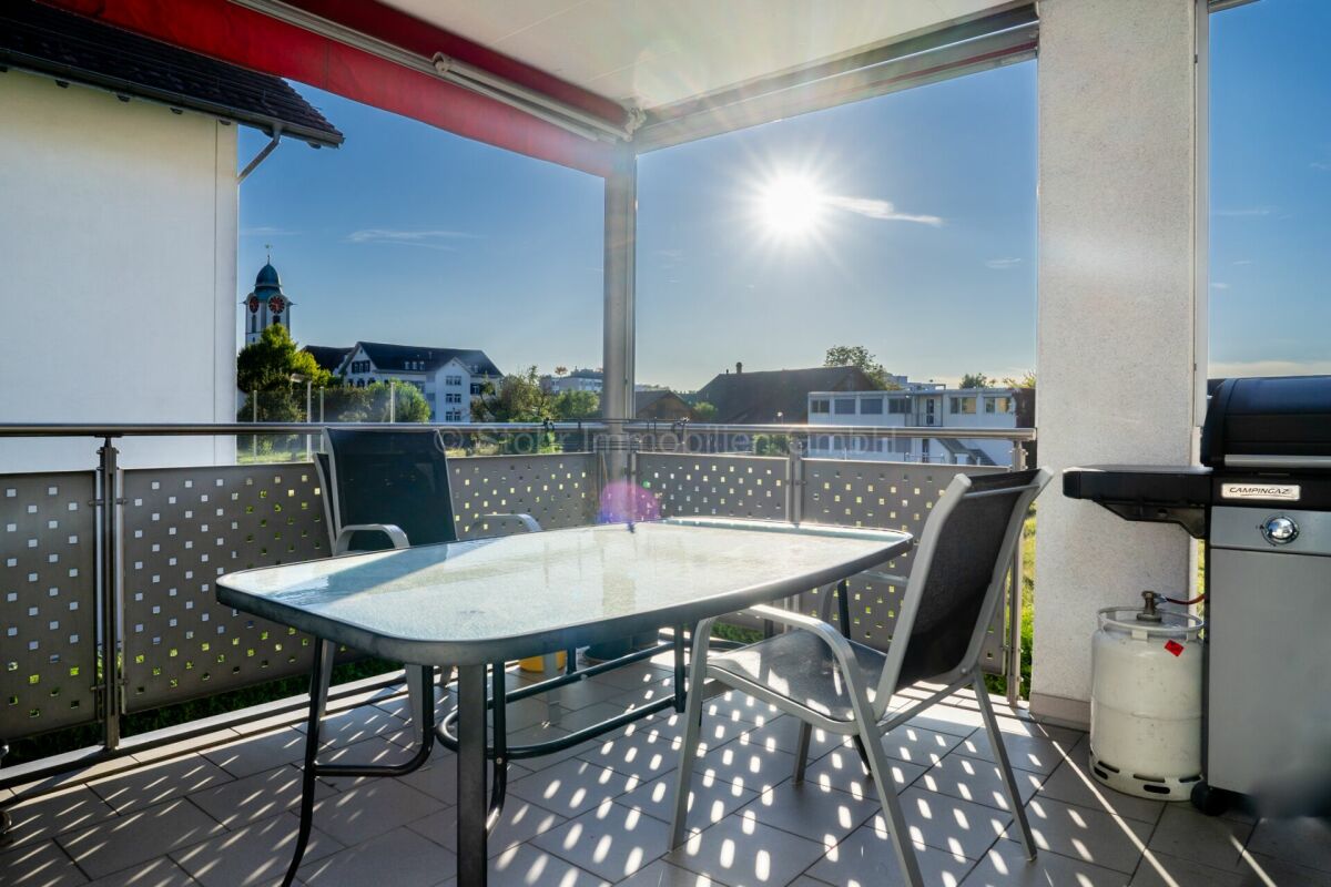 Sonnige Dachterrasse mit Esstisch und Grill