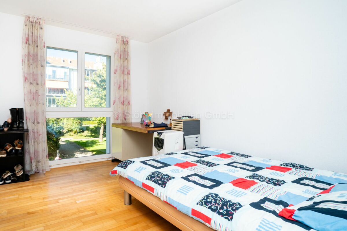 Helles Schlafzimmer mit großem Fenster und Blick ins Grüne