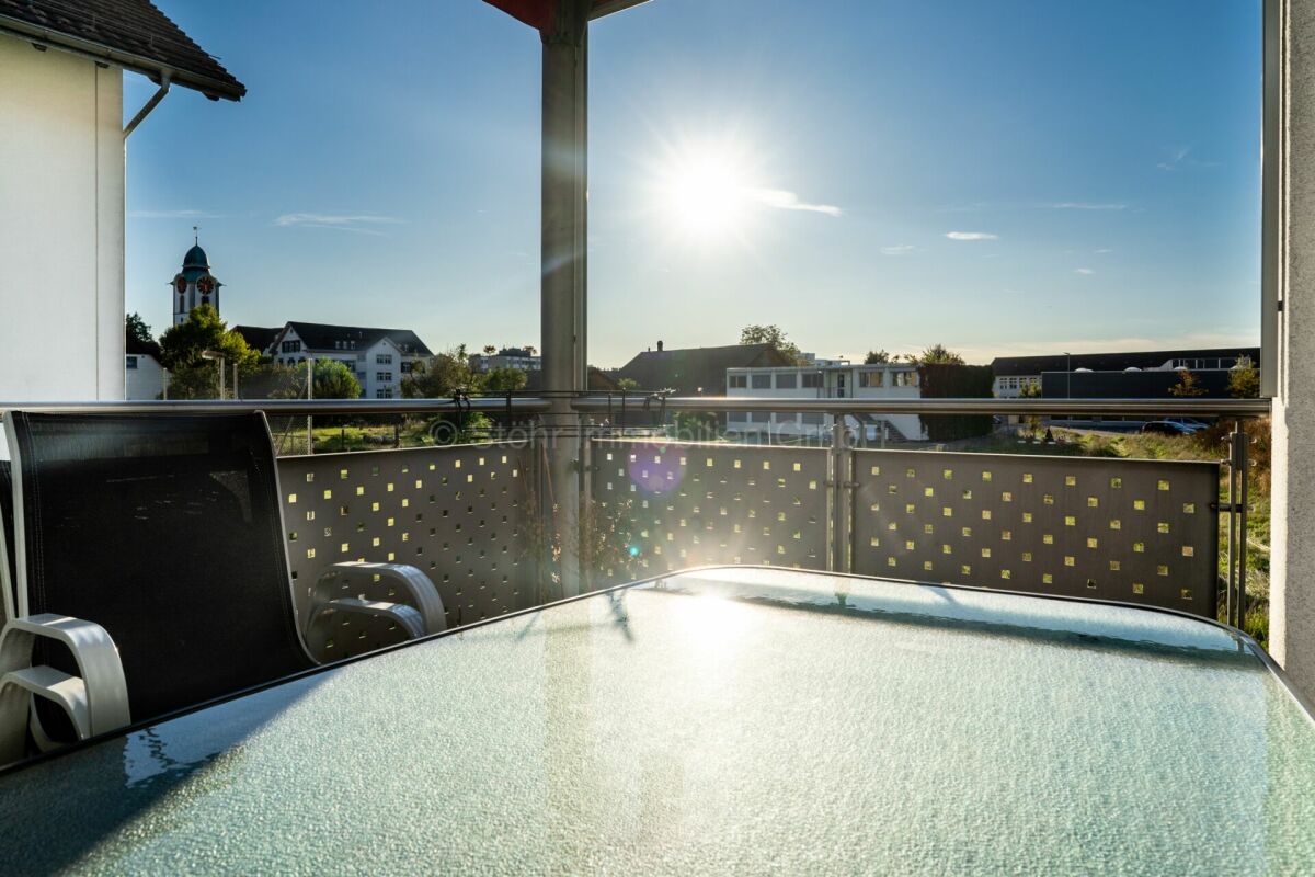 Balkon mit Tisch und Ausblick bei tief stehender Sonne