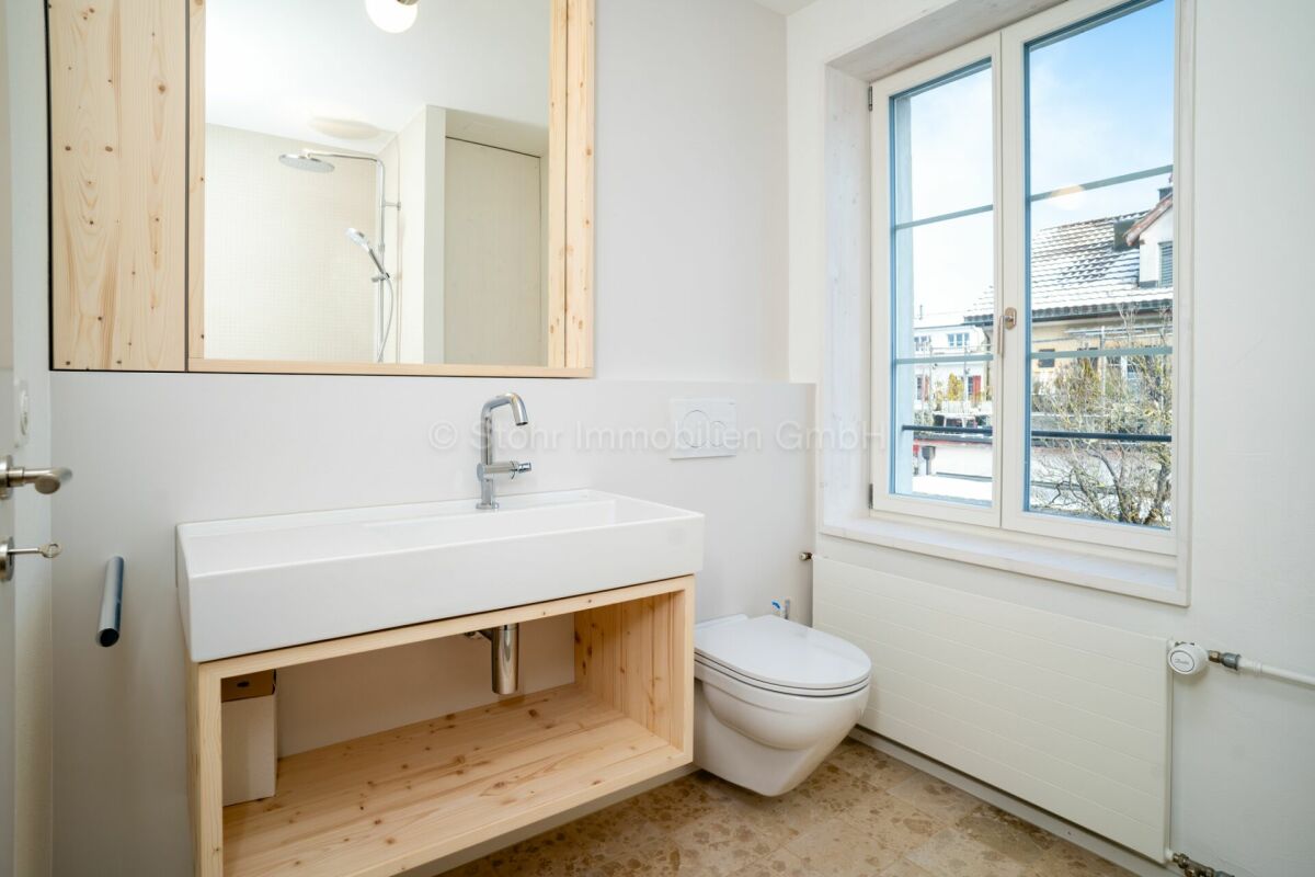 Helles Gäste-WC mit Holzwaschtisch und Fenster