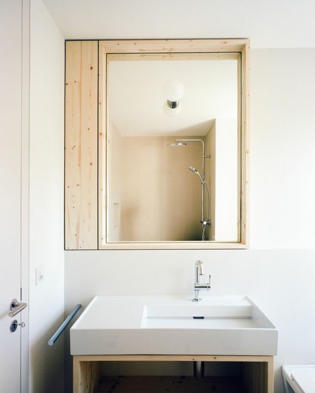 Helles Badezimmer mit Waschtisch und Spiegel über der Dusche