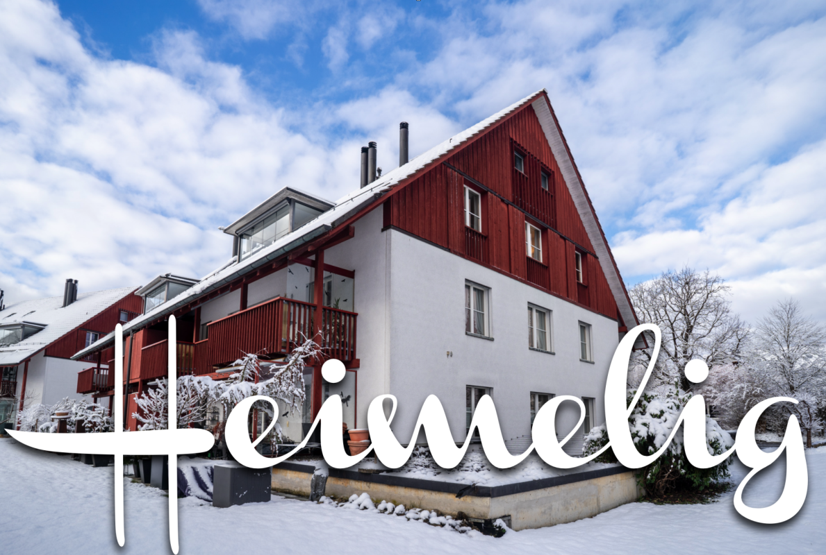 Schneebedecktes Wohnhaus mit roter Holzfassade
