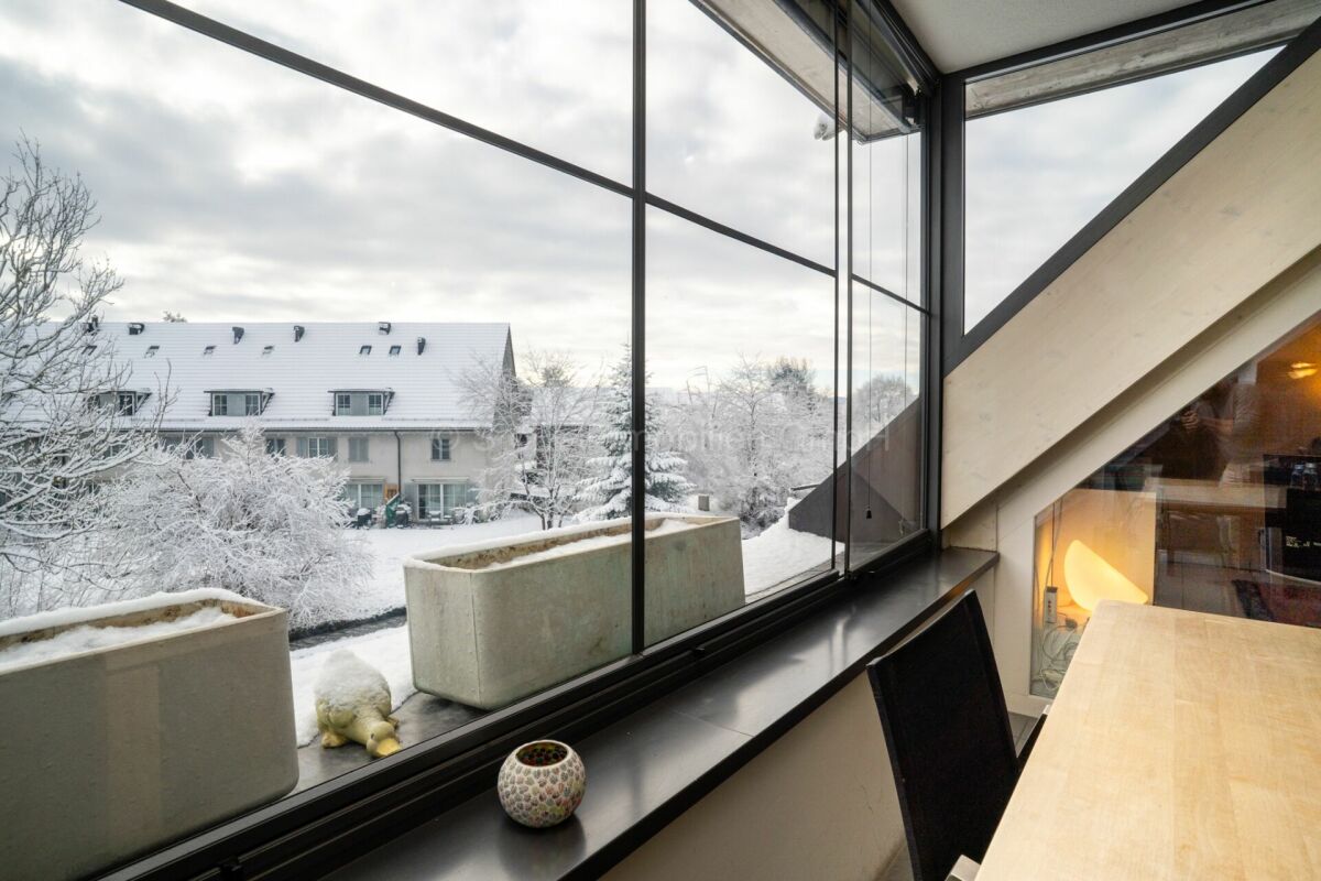 Dachgeschossraum mit großem Panoramafenster und Winterblick