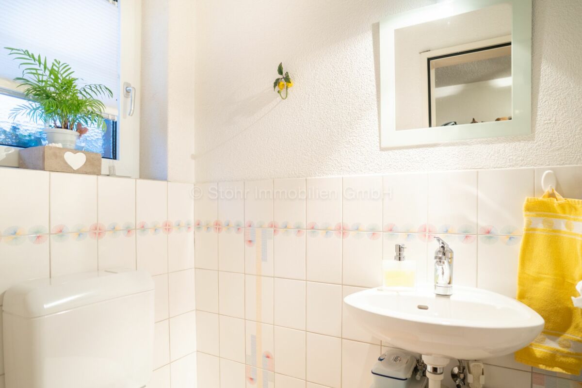 Helles Gäste-WC mit Waschbecken und Fenster