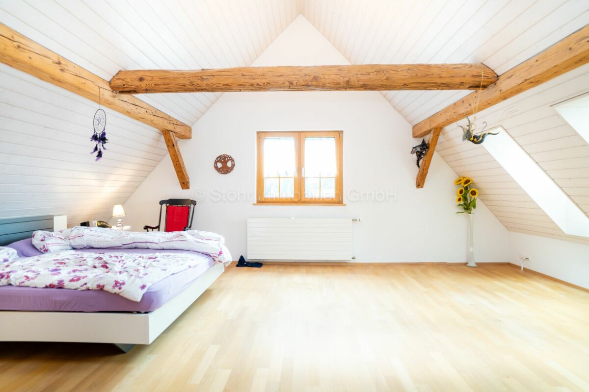 Dachgeschoss-Schlafzimmer mit Holzbalken
