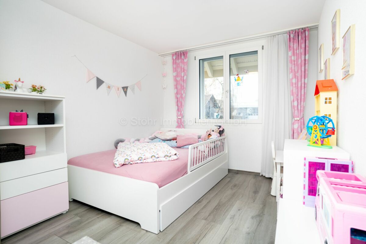 Helles Kinderzimmer mit weißer Möblierung und rosa Akzenten