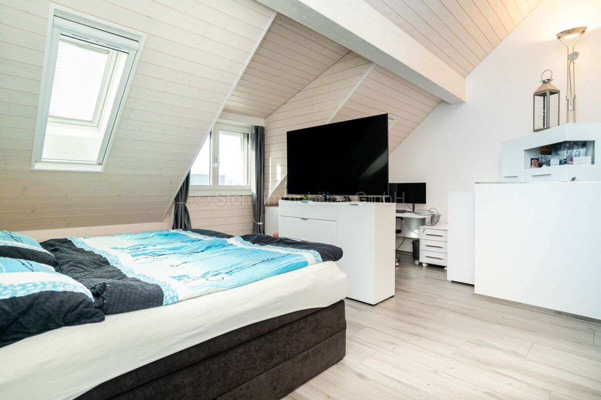 Dachgeschoss-Schlafzimmer mit Fernseher