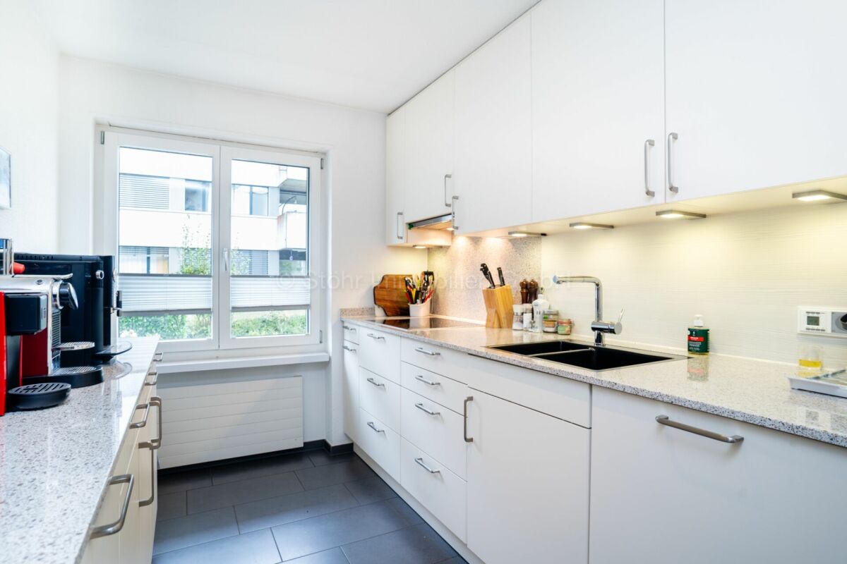 Helle, moderne Küche mit weißer Einbautenwand