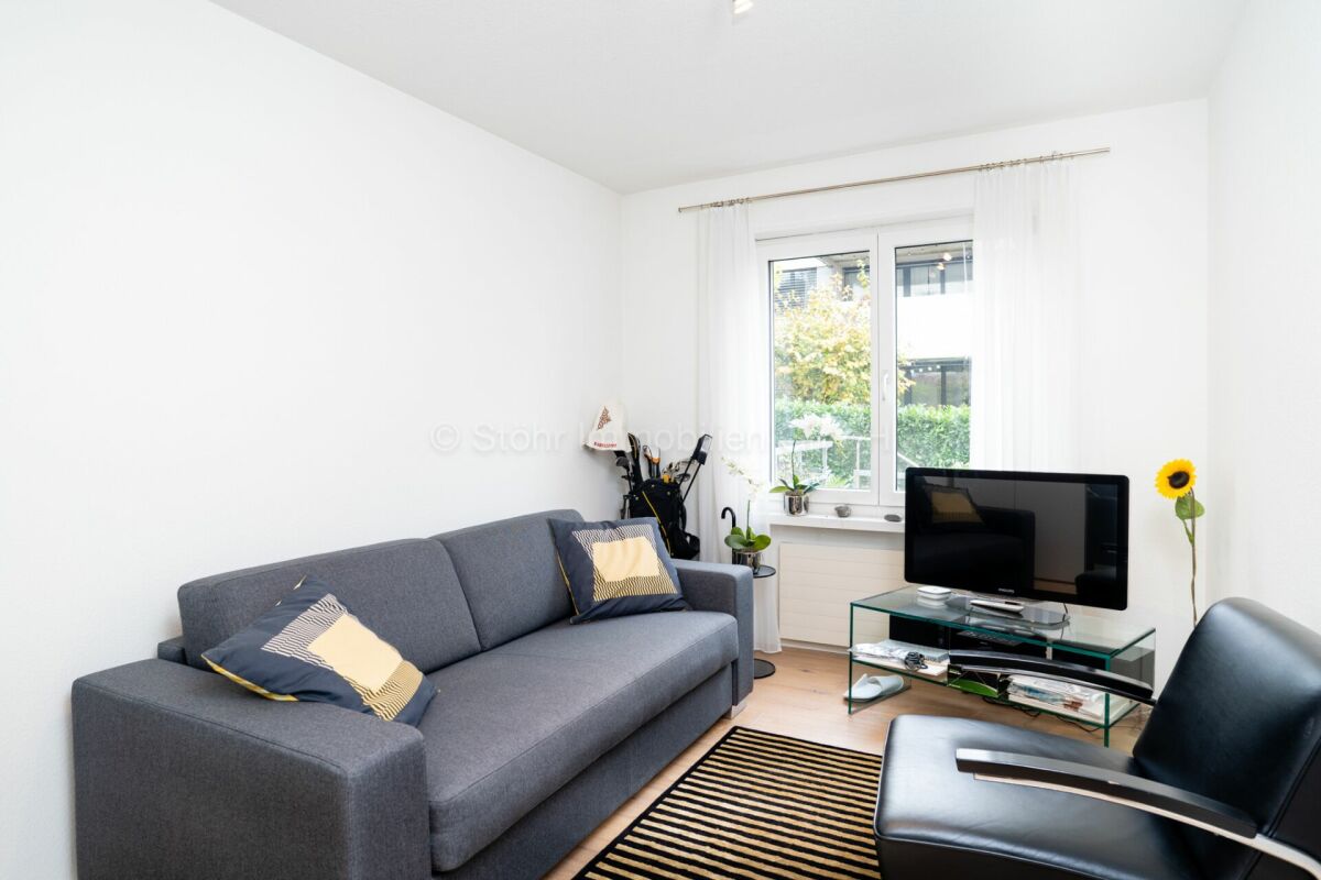 Helles Wohnzimmer mit Sofa und TV