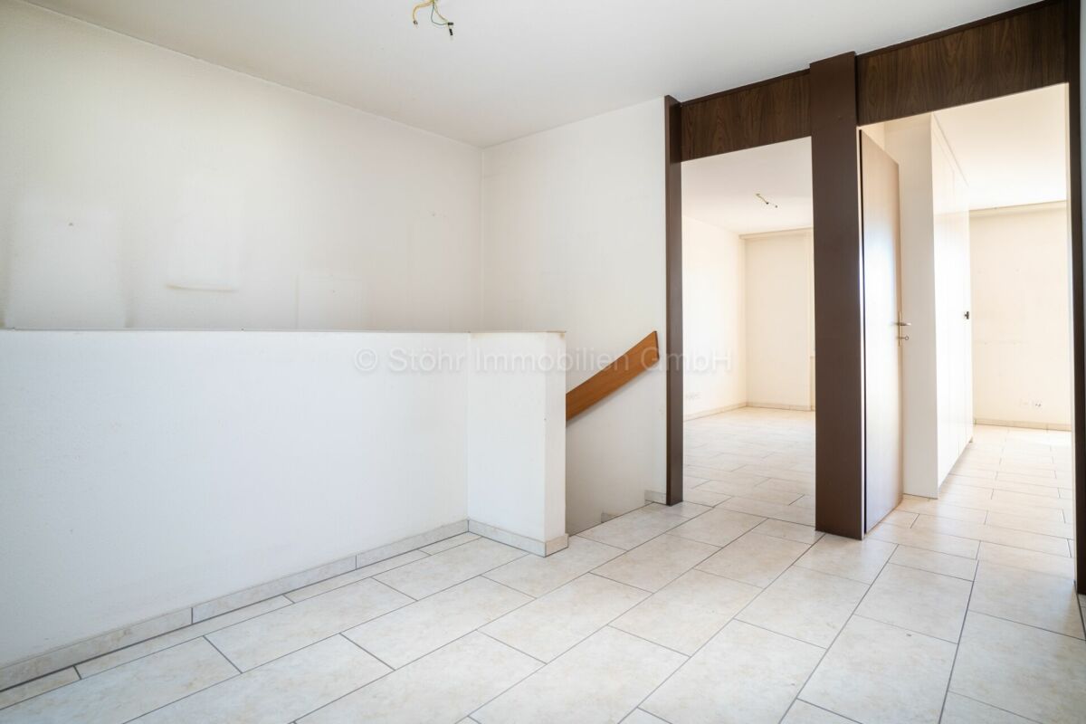 Heller Flur mit Treppe und Türdurchgängen
