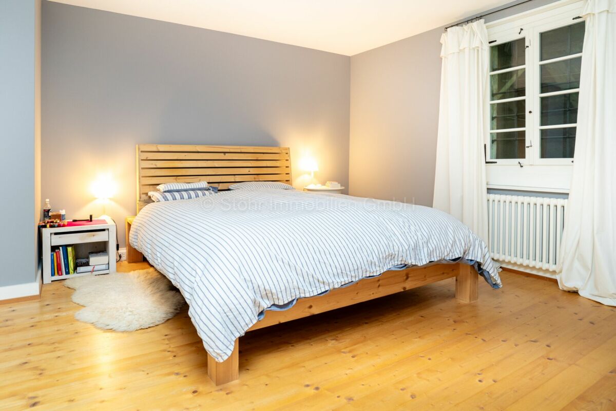 Helles Schlafzimmer mit Holzbett und Fenster