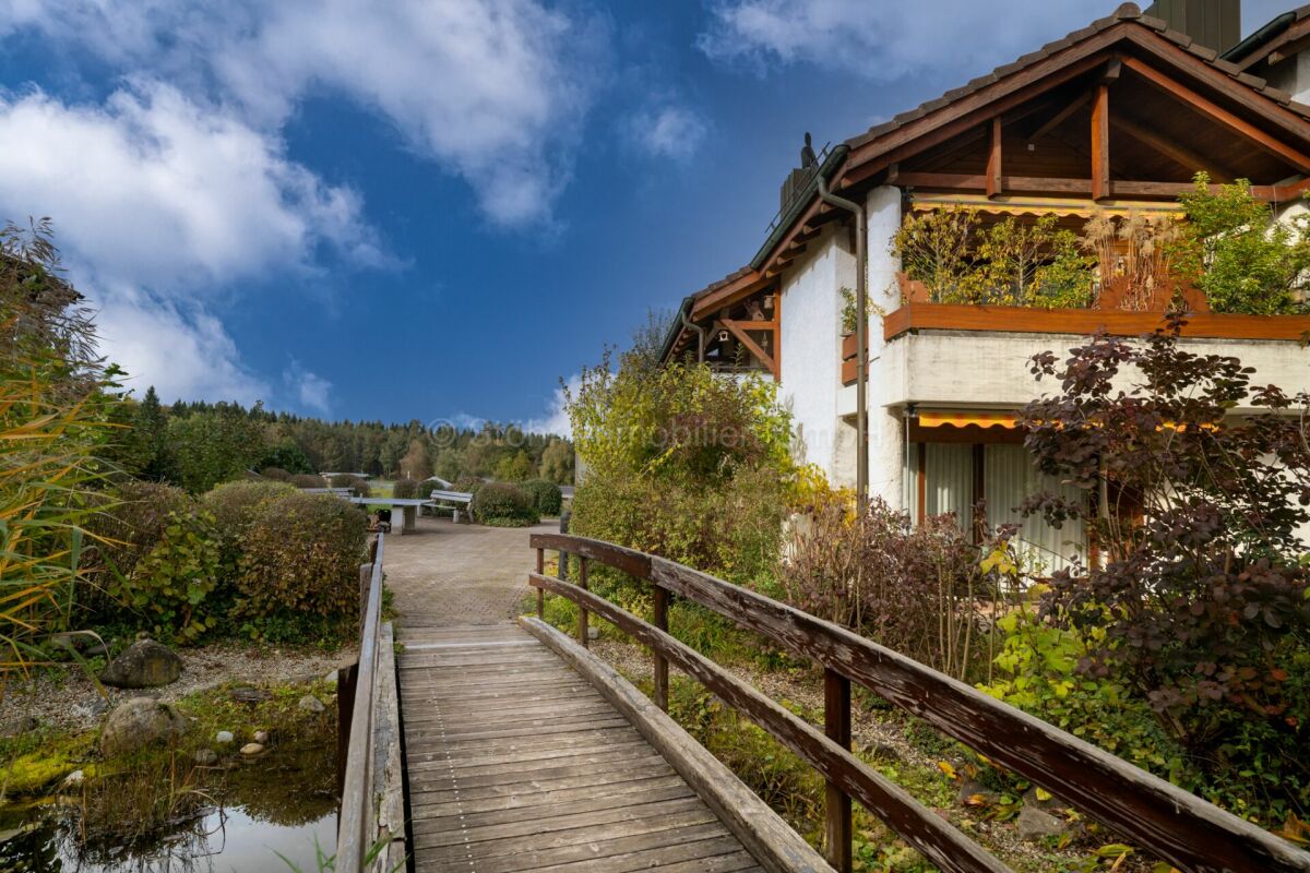 Außenansicht eines Hauses mit Garten und Holzbrücke